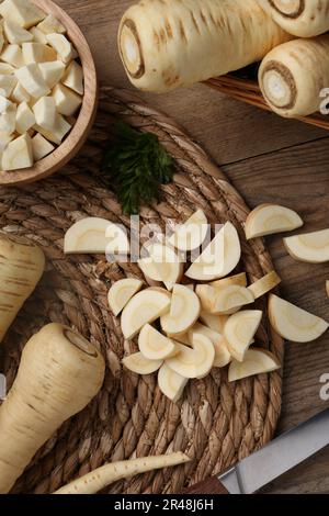 Whole and cut parsnips on wooden table, flat lay Stock Photo