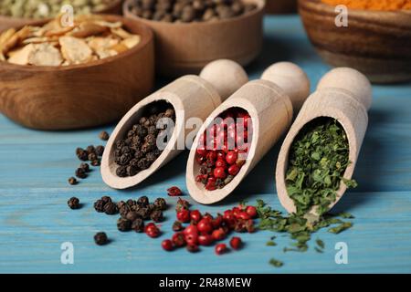 Scoops with different spices on light blue wooden table Stock Photo