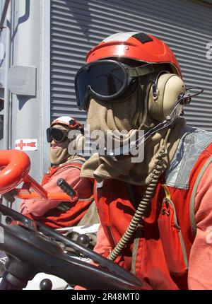 US Navy Crash and Salvage personnel aid in repositioning the flight ...