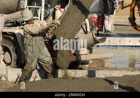 US Navy Seabees attached to Naval Mobile Construction Battalion Seventy-Four (NMCB-74) pour concrete for a C-130 aircraft staging area Stock Photo