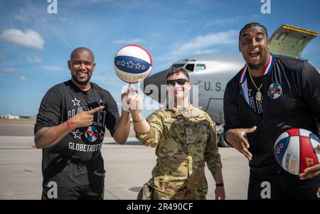 Shane “Scooter” Christensen, left, and Joey “Hot Rod” De La Rosa, right, members of the Harlem Globetrotters, pose for a photo on the flightline during a base tour with Airman 1st Class Dakota Gross, 50th Air Refueling Squadron boom operator, at MacDill Air Force Base, Florida, April 6, 2023. The players interacted with servicemembers and gained a better understanding of the Air Force mission during the tour. U.S. Air Force photo by Senior Airman Lauren Cobin) Stock Photo