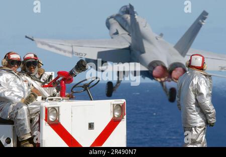 US Navy Crash and Salvage crew members standby on the bow of USS Carl Vinson (CVN 70) in case of an emergency Stock Photo