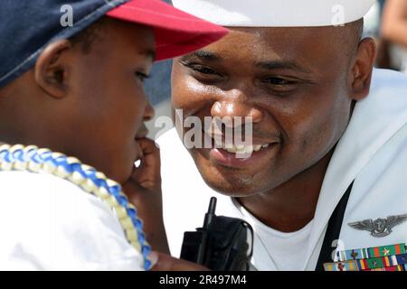 US Navy Yeoman 1st Class gets reacquainted with his son on the pier after the guided missile frigate USS Crommelin (FFG 37) returned home from a six-month deployment from the U.S. Naval Fo Stock Photo