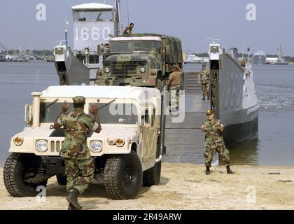 US Navy Personnel assigned to Naval Beach Group Two (NBG-2) load vehicles from NBG-2, and Amphibious Construction Battalion Two (ACB-2) onto Landing Craft Utility (LCU) 1660 from Assault Craft Unit Two (ACU-2 Stock Photo
