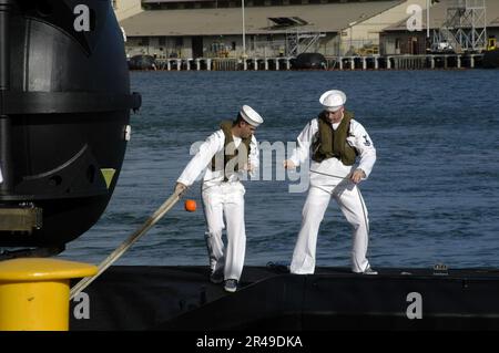 US Navy Line handlers aboard USS Los Angeles (SSN 688) bring mooring lines across to secure the submarine to its berth in Pearl Harbor Stock Photo