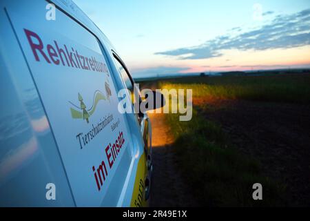 Knetzgau, Germany. 15th May, 2023. A car with the inscription 'Rehkitzrettung' (fawn rescue) stands on a dirt road near Knetzgau at dawn. Modern technology is currently being used to search meadows in Bavaria to prevent fawns from being killed during mowing. (to dpa: 'Before the mower approaches: Search for fawns in the meadow') Credit: Pia Bayer/dpa/Alamy Live News Stock Photo