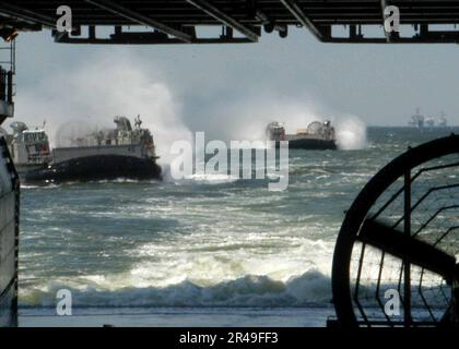 US Navy Landing Craft Air Cushions approach the well deck Stock Photo