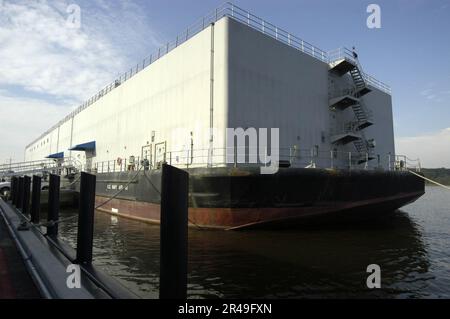 US Navy The U.S. Navy Barracks Craft Auxiliary Personnel Lighter Sixty One (APL-61) is moored alongside the U.S. Naval Academy's Dewey Seawall Stock Photo