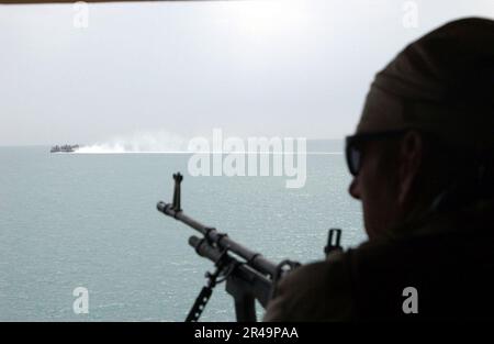 US Navy Personnel assigned to Mobile Inshore Undersea Warfare Unit Two Zero Six (MIUW 206) provide surveillance of the beach and water along Kuwait Naval Base in the early morning Stock Photo