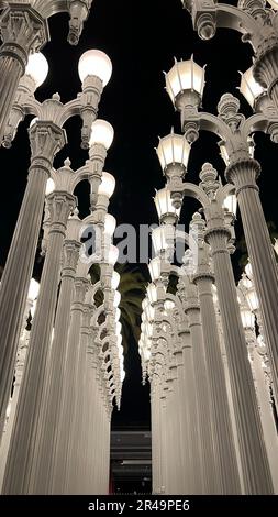 An illuminated scene of a city street at night featuring a row of street lamps in Los Angeles Stock Photo