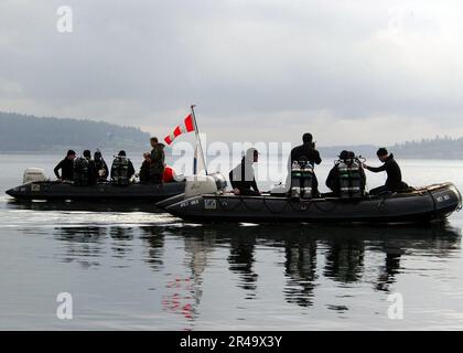 US Navy U.S. Navy divers assigned to the Naval Reserves (NR) Explosive Ordnance Disposal Mobile Unit One Seven (EOD-MU 17) transit Crescent Harbor near Naval Air Station Whidbey Island Stock Photo