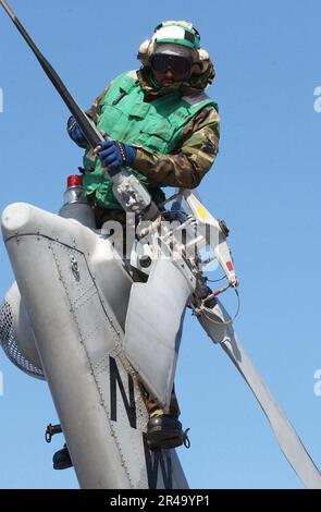 US Navy Aviation Machinist's Mate performs maintenance on the tail rotor of an SH-60 Seahawk Stock Photo