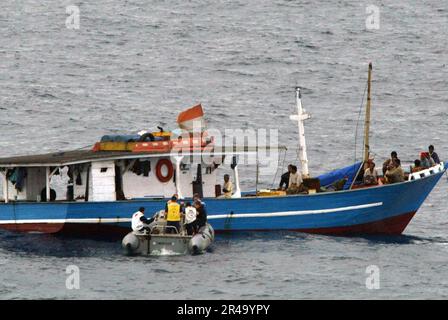 US Navy Crew members assigned to the guided missile cruiser USS Chancellorsville (CG 62) approach the stranded Indonesian fishing vessel Adem Laut Stock Photo