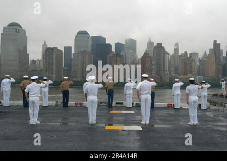 US Navy Sailors and Marines man the rails aboard the amphibious assault ship USS Iwo Jima (LHD 7) as she sails into New York Harbor Stock Photo