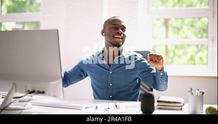 Happy Designer Listening Music In Headphones At Work Stock Photo