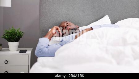 Young Happy Smiling African Man Waking Up At Bedroom Stock Photo