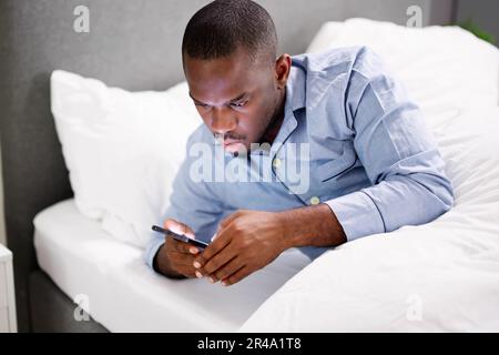 African Man Holding Smartphone Or Mobile Phone Stock Photo