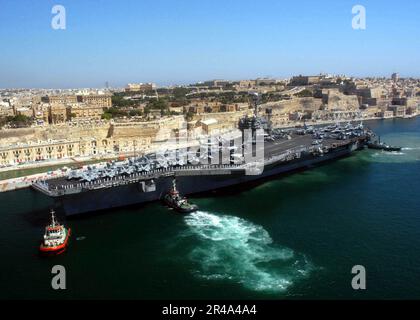 US Navy Tugboats assist the conventionally powered aircraft carrier USS John F. Kennedy (CV 67) while pulling pier-side in the port of Valletta, Malta Stock Photo