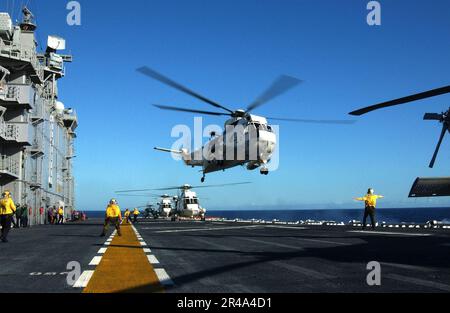 US Navy A UH-3H Sea King helicopter takes off from the flight deck of the amphibious assault ship USS Tarawa (LHA 1) Stock Photo