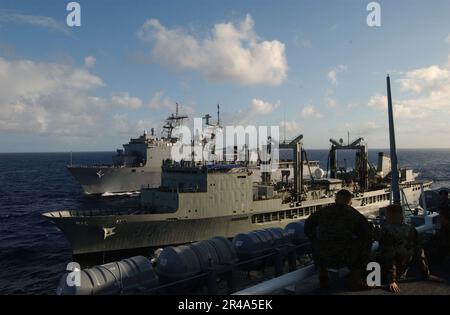 Sailors observe the amphibious assault ship USS Peleliu (LHA-5) pulling ...
