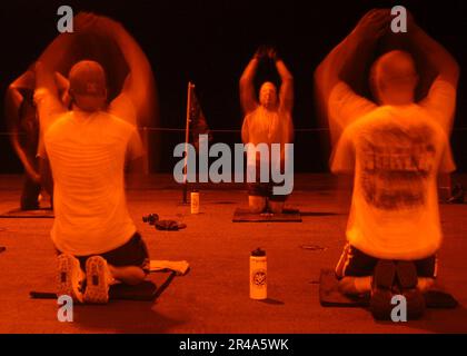 US Navy Crew members take time for physical fitness training the ship's hangar bay aboard USS John F. Kennedy (CV 67) Stock Photo