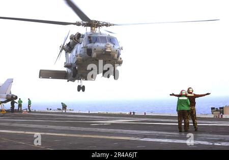 US Navy Landing Signal Enlisted (LSE) Personnel assigned to the Chargers of Helicopter Anti-Submarine Squadron One Four (HS-14) signal to an HH-60H Seahawk helicopter aboard USS Kitty Hawk (CV 63) Stock Photo