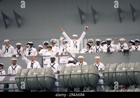 US Navy An anxious Sailor aboard USS Ronald Reagan (CVN 76) waves to a loved one during the ship's arrival at Naval Station North Island, San Diego, Calif Stock Photo