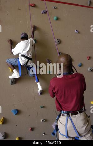 US Navy Yeoman 1st Class assists his son up the rock-wall at the Smoky Point Naval Support Complex during the first phase of the Drug Education for Youth (DEFY) Program Stock Photo