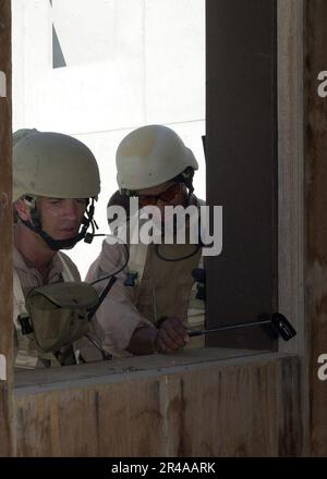 US Navy Steel Worker 1st Class and Sonar Technician Jry, both assigned to Explosive Ordnance Disposal Mobile Unit Four, Detachment Four, perform reconnaissance of a building Stock Photo