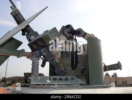 US Navy Construction Electrician 1st Class assigned to the Tactical Movement Team (TMT) of Naval Mobile Construction Battalion Two Three (NMCB-23), scans the Fallujah horizon Stock Photo