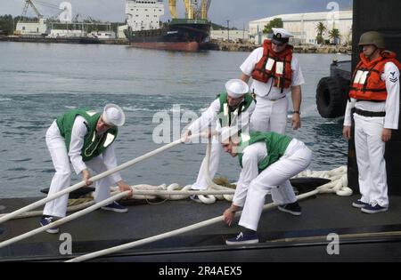 US Navy Crew members haul in the mooring lines aboard the nuclear-powered Los Angeles-class fast attack submarine USS Houston (SSN 713) Stock Photo