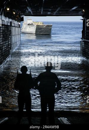 A landing craft utility maneuvers into the well deck of the amphibious ...