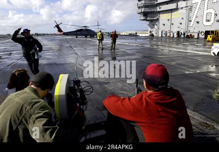 US Navy A member of an NBC television crew shouts Roll Camera, ACTION^ as he runs to the back of the set for a new television show called Fathom during filming on the flight deck aboard USS Ronald Reagan (CVN Stock Photo