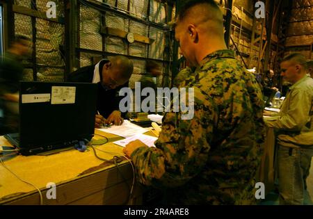 US Navy Yeoman 1st Class assigned to Joint Reception Personnel, Osan Air Force Base, in-processes Gunnery Sgt. in preparation for Reception, Staging, Onward movement, and Integr Stock Photo