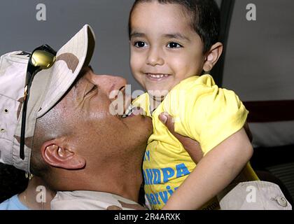 US Navy  A Sailor assigned to Naval Expeditionary Logistics Support Force Reservists (NAVELSF), hugs a loved one after returning from deployment at the Air Mobility Command Terminal on board Naval Station Norf. Stock Photo