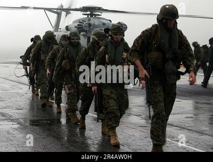 US Navy  Marines assigned to the 26th Marine Expeditionary Unit exit a CH-53E Super Stallion helicopter and transit the flight deck aboard the amphibious assault ship USS Kearsarge (LHD 3). Stock Photo