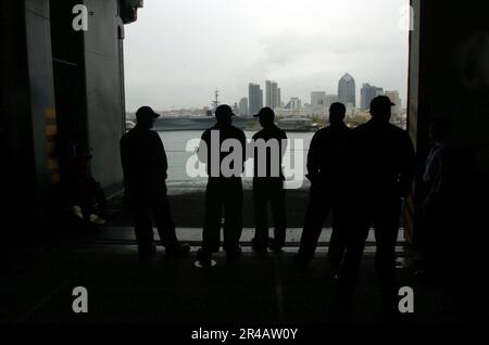 Sailors aboard the USS Peleliu stand in formation on the rails during ...