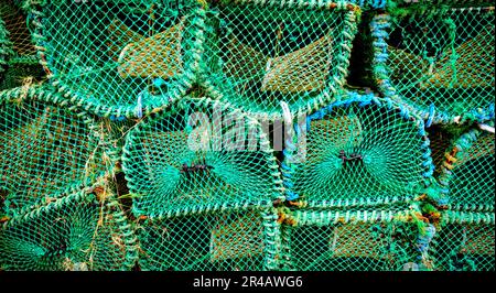 Creels piled up in the harbour in Arinagour, Island of Coll, Scotland Stock Photo