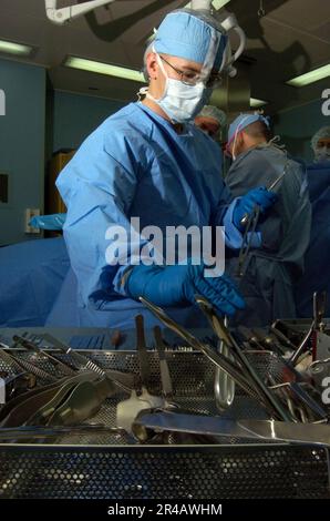 US Navy  Hospitalman organizes operating tools used by the medical personnel aboard the Military Sealift Command (MSC) hospital ship USNS Mercy (T-AH 19) as they conduct an oper. Stock Photo