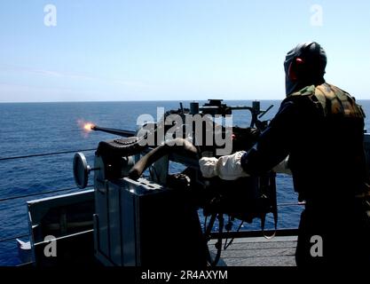 US Navy  Gunner's Mate Seaman fires a MK-38 25mm machine gun system during a training exercise aboard the amphibious assault ship USS Boxer (LHD 4). Stock Photo