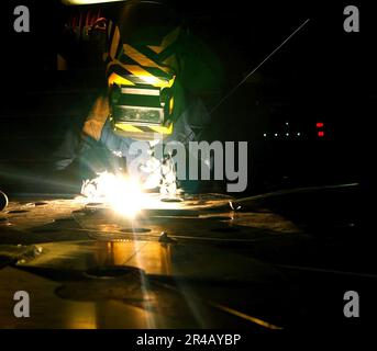 US Navy Hull Technician Fireman practices welding techniques aboard the ...