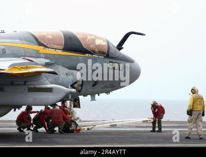 US Navy  Crash and Salvage crew members attach a tow-bar to an EA-6B Prowler assigned to the Yellow Jackets of Electronic Attack Squadron One Three Eight (VAQ-138). Stock Photo