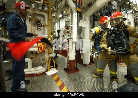 US Navy Damage Control Training Team member, Hull Technician 1st Class simulates a Class Bravo fire in the fire room Stock Photo