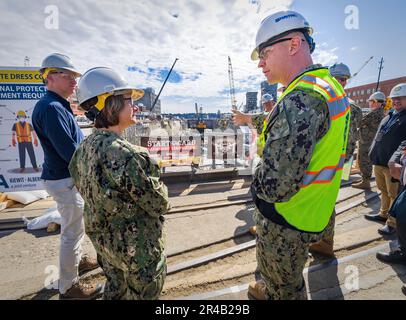 The Honorable Erik Raven, Under Secretary of the Navy, and Adm. Lisa Franchetti, Vice Chief of Naval Operations, discuss ongoing seismic mitigations at Dry Dock 4 at Puget Sound Naval Shipyard & Intermediate Maintenance Facility in Bremerton, Washington, March 29, 2023. Raven and Franchetti met with shipyard leadership during their visit to discuss infrastructure upgrades and work planned as part of the Shipyard Infrastructure Optimization Program, the Navy’s once-in-a-century investment to reconfigure, modernize and optimize its four aging public shipyards. Stock Photo