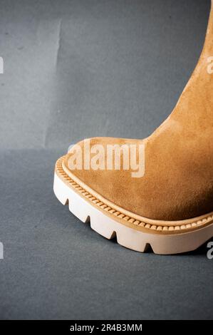 A museum display featuring two shoes, one black and one brown in color, both resting on a white platform Stock Photo