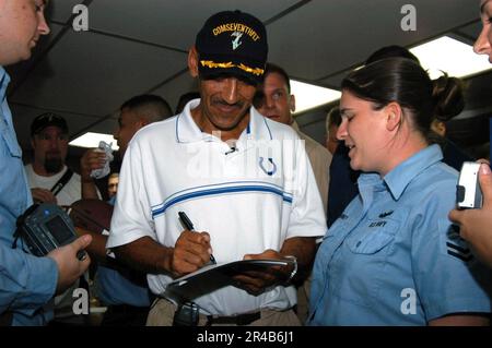 US Navy  The head coach of the Indianapolis Colts football team Tony Dungy signs an autograph for Information Systems Technician 2nd Class aboard the command ship. Stock Photo
