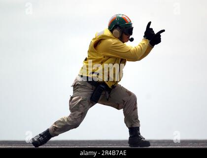 US Navy  Catapult shooter, Lt. gives the launch signal to an aircraft as it launches from the flight deck of USS Ronald Reagan (CVN 76). Stock Photo