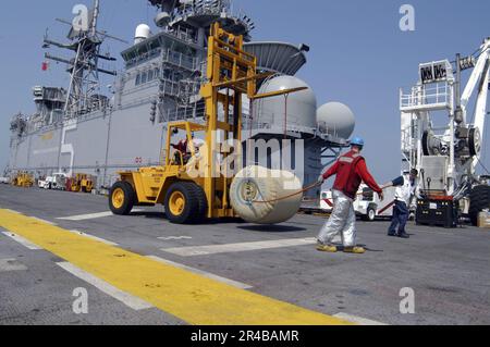 US Navy  Crash and Salvage crew members aboard amphibious assault ship USS Bataan (LHD 5) move a 500 gallon rubber bladder filled with fresh drinking water for Hurricane Katrina relief efforts. Stock Photo