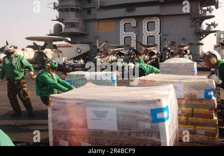 US Navy  Crew members move pallets of supplies aboard the nuclear powered carrier USS Nimitz (CVN 68) during a vertical replenishment. Stock Photo
