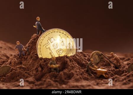 Miner digging ground to uncover big Gold bitcoin. Cryptocurrency Bitcoin Mining concept Stock Photo